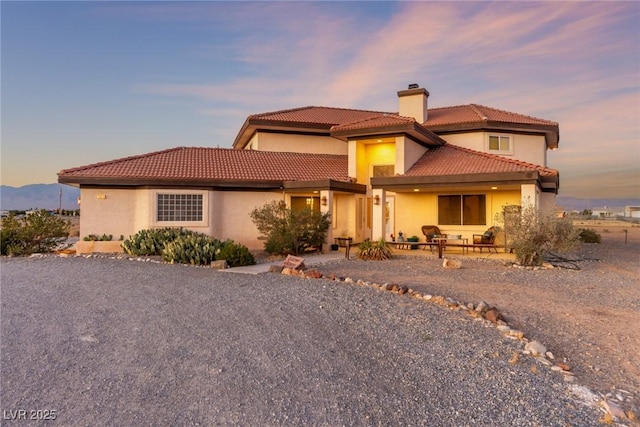 3821 Tumbleweed Ave, Pahrump, NV 89048 - mediterranean / spanish home with a chimney, stucco siding, a patio, and a tiled roof