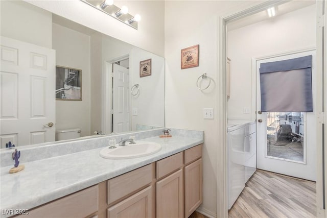 3821 Tumbleweed Ave, Pahrump, NV 89048 - bathroom featuring washer and dryer, wood finished floors, and vanity