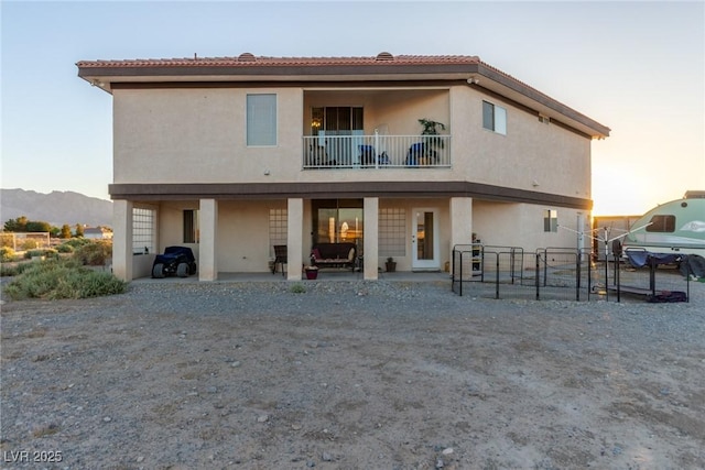 3821 Tumbleweed Ave, Pahrump, NV 89048 - back of property featuring a balcony, a patio area, stucco siding, and a tiled roof