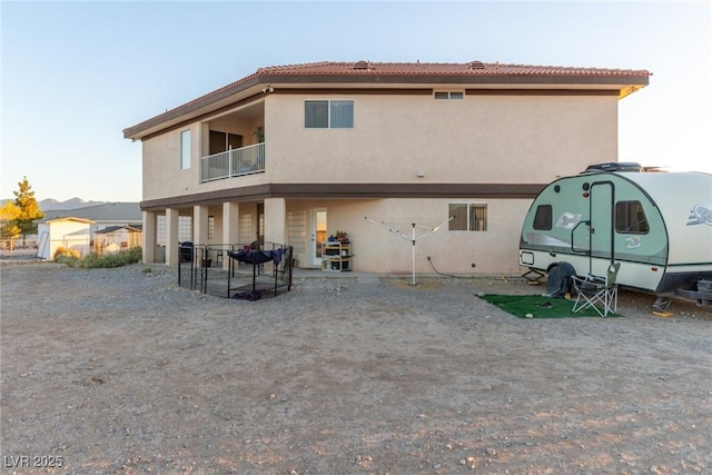 3821 Tumbleweed Ave, Pahrump, NV 89048 - rear view of house featuring stucco siding and a balcony