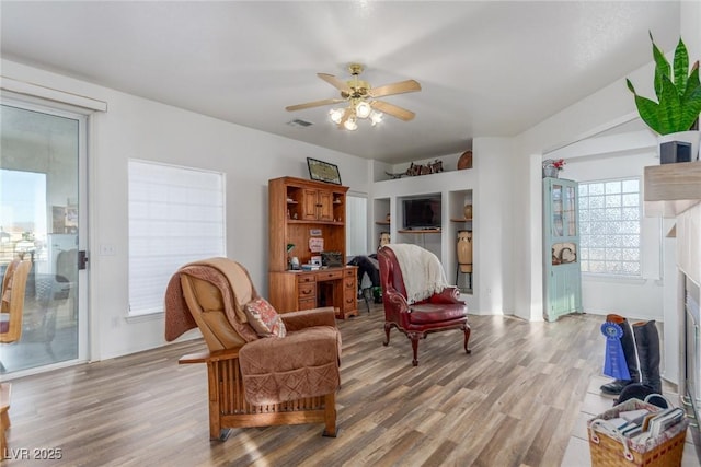 3821 Tumbleweed Ave, Pahrump, NV 89048 - living area featuring light wood-style floors, a ceiling fan, and a fireplace