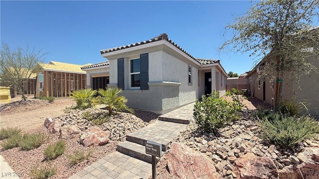 739 Wild Highlands Ln, Henderson, NV 89015 - view of side of property with a tiled roof, stucco siding, and a garage