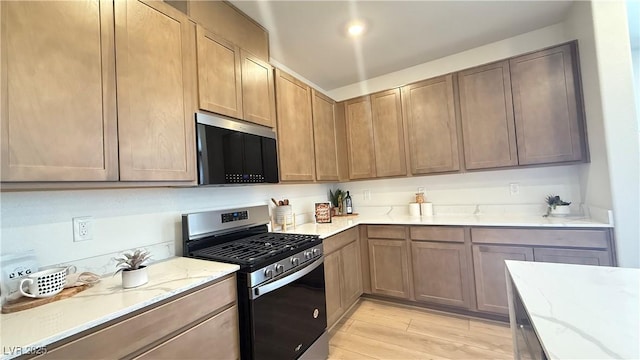 739 Wild Highlands Ln, Henderson, NV 89015 - kitchen with appliances with stainless steel finishes, light stone counters, and light wood-style flooring