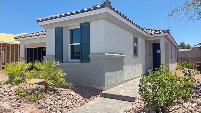 739 Wild Highlands Ln, Henderson, NV 89015 - view of home's exterior with a tiled roof, an attached garage, and stucco siding