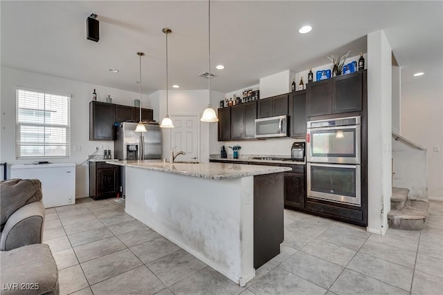 889 Harbor Ave, Henderson, NV 89002 - kitchen with appliances with stainless steel finishes, dark brown cabinetry, light tile patterned floors, light stone countertops, and decorative light fixtures