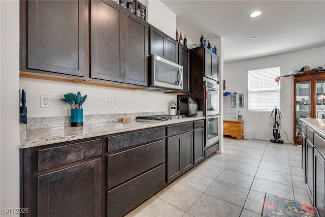 889 Harbor Ave, Henderson, NV 89002 - kitchen with appliances with stainless steel finishes, light stone counters, dark brown cabinets, recessed lighting, and light tile patterned flooring
