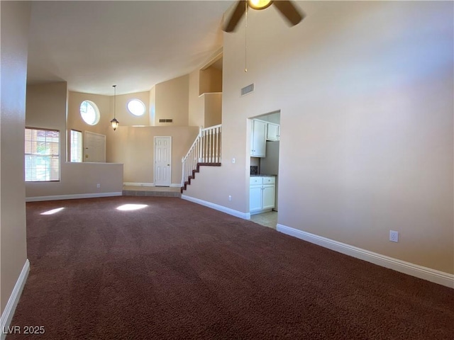 7604 Cruz Bay Ct, Las Vegas, NV 89128 - unfurnished living room with high vaulted ceiling, a ceiling fan, light carpet, and stairway