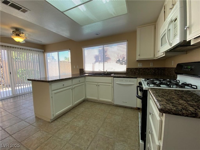 7604 Cruz Bay Ct, Las Vegas, NV 89128 - kitchen with white appliances, a peninsula, a ceiling fan, and dark stone counters