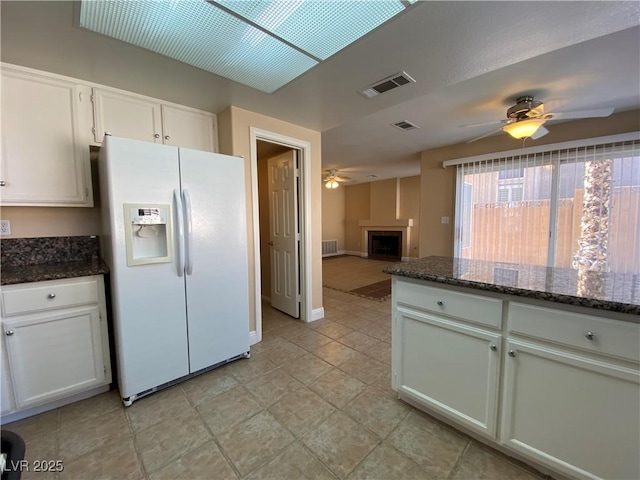7604 Cruz Bay Ct, Las Vegas, NV 89128 - kitchen with white fridge with ice dispenser, ceiling fan, white cabinets, and dark stone countertops