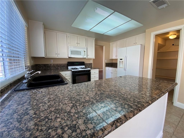 7604 Cruz Bay Ct, Las Vegas, NV 89128 - kitchen featuring white appliances, a peninsula, white cabinets, and dark stone countertops