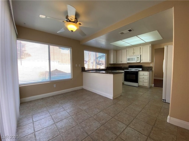 7604 Cruz Bay Ct, Las Vegas, NV 89128 - kitchen with white appliances, a peninsula, dark countertops, ceiling fan, and white cabinetry