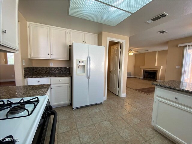 7604 Cruz Bay Ct, Las Vegas, NV 89128 - kitchen featuring white refrigerator with ice dispenser, ceiling fan, white cabinetry, and dark stone countertops
