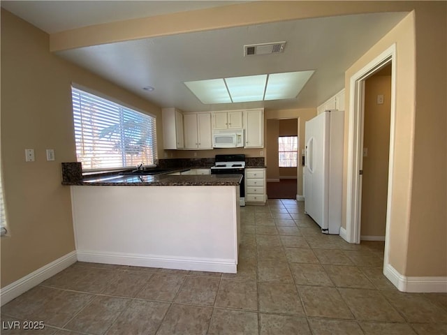 7604 Cruz Bay Ct, Las Vegas, NV 89128 - kitchen with white appliances, a peninsula, white cabinetry, light tile patterned floors, and dark stone counters