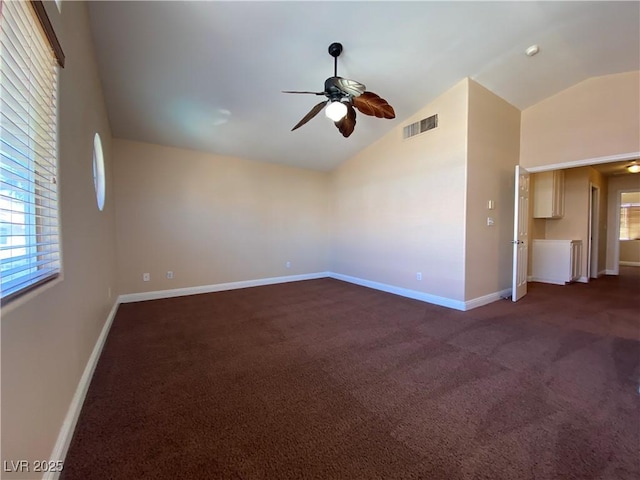7604 Cruz Bay Ct, Las Vegas, NV 89128 - spare room featuring vaulted ceiling, a ceiling fan, dark carpet, and healthy amount of natural light