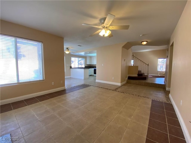 7604 Cruz Bay Ct, Las Vegas, NV 89128 - unfurnished living room featuring ceiling fan, tile patterned floors, stairs, and arched walkways