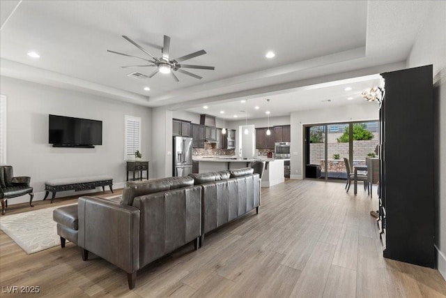 251 Castellari Dr, Las Vegas, NV 89138 - living room with a raised ceiling, a ceiling fan, recessed lighting, and light wood-type flooring
