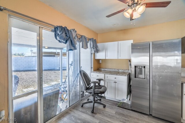 2450 Tournament St, Las Vegas, NV 89142 - kitchen with stainless steel fridge with ice dispenser, light wood finished floors, white cabinets, and ceiling fan