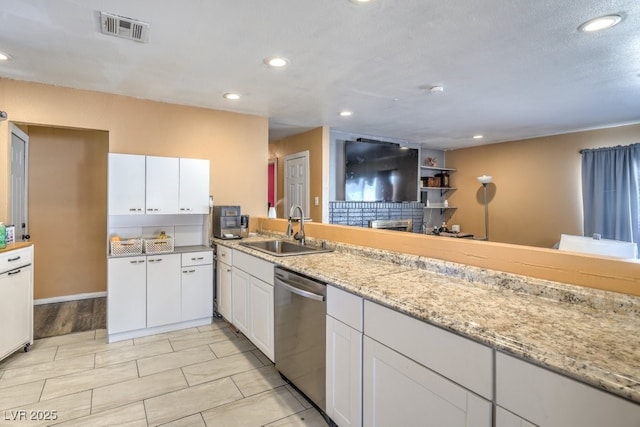 2450 Tournament St, Las Vegas, NV 89142 - kitchen with stainless steel dishwasher, white cabinets, recessed lighting, and light stone countertops