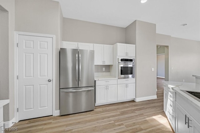 10700 Button Willow Dr, Las Vegas, NV 89134 - kitchen with appliances with stainless steel finishes, white cabinets, light wood-type flooring, and light stone counters