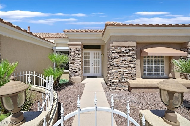 10700 Button Willow Dr, Las Vegas, NV 89134 - view of exterior entry with stone siding, french doors, stucco siding, and a tiled roof