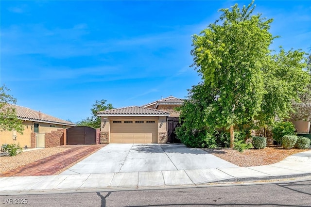1727 Sonoran Bluff Ave, Henderson, NV 89014 - obstructed view of property with a gate, stucco siding, concrete driveway, a tiled roof, and stone siding