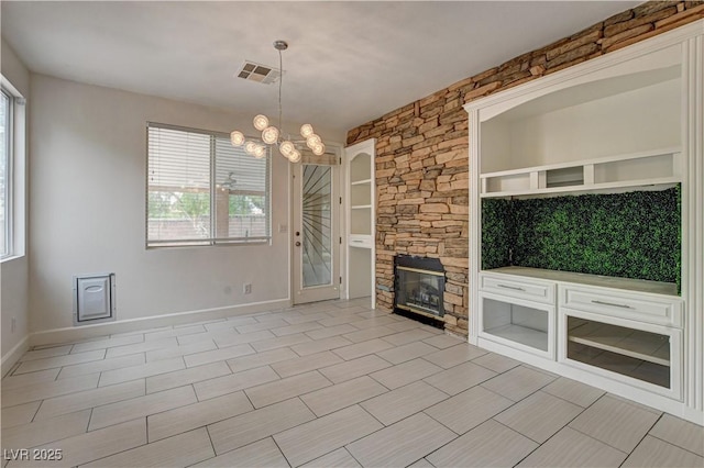 3200 Ridgecliff St, Las Vegas, NV 89129 - unfurnished living room featuring a chandelier and a stone fireplace