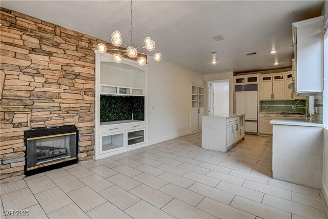 3200 Ridgecliff St, Las Vegas, NV 89129 - kitchen featuring paneled refrigerator, light countertops, decorative backsplash, a kitchen island, and a fireplace