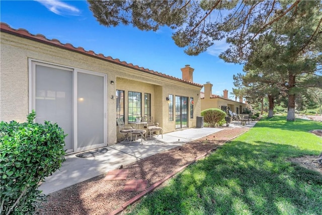 7909 Canoe Ln, Las Vegas, NV 89145 - rear view of property with a patio area, stucco siding, a yard, a chimney, and a tile roof