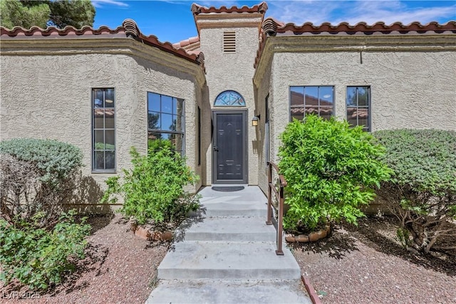 7909 Canoe Ln, Las Vegas, NV 89145 - doorway to property featuring stucco siding and a tiled roof