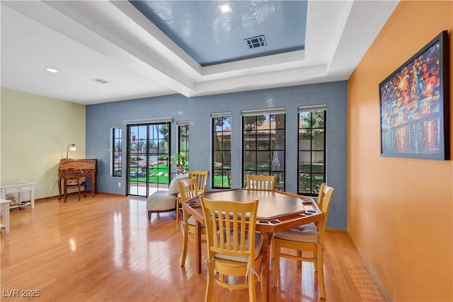 7909 Canoe Ln, Las Vegas, NV 89145 - dining space with a tray ceiling and light wood-style flooring