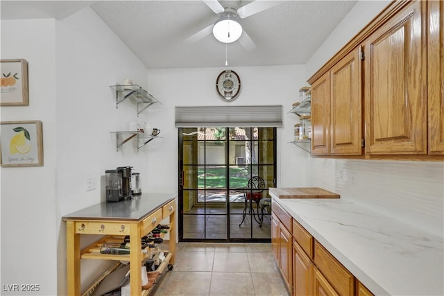 7909 Canoe Ln, Las Vegas, NV 89145 - kitchen featuring light tile patterned flooring, brown cabinetry, a ceiling fan, backsplash, and open shelves