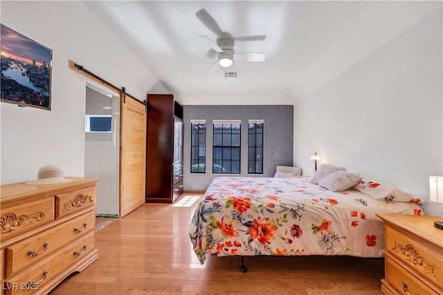 7909 Canoe Ln, Las Vegas, NV 89145 - bedroom featuring a barn door, light wood-style flooring, and a ceiling fan