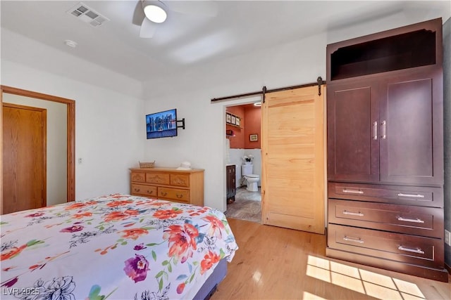 7909 Canoe Ln, Las Vegas, NV 89145 - bedroom featuring a barn door, light wood finished floors, ensuite bath, and a ceiling fan