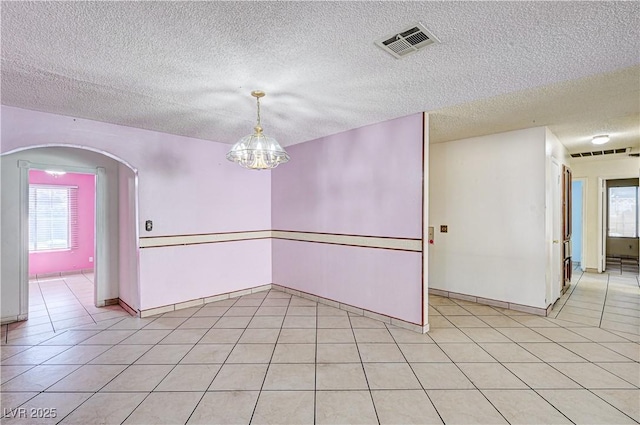 5121 Gains Mill St, Las Vegas, NV 89122 - unfurnished room featuring plenty of natural light, light tile patterned floors, arched walkways, a textured ceiling, and a chandelier