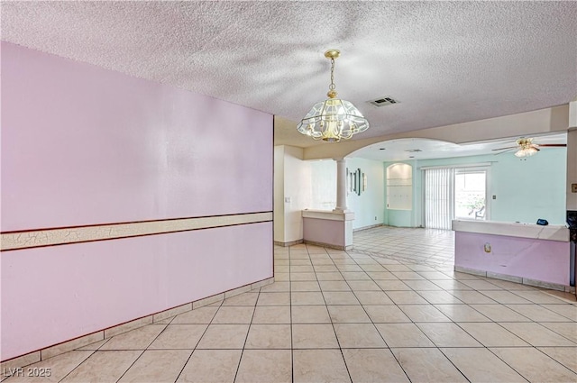 5121 Gains Mill St, Las Vegas, NV 89122 - unfurnished room with arched walkways, ceiling fan, a textured ceiling, ornate columns, and light tile patterned flooring