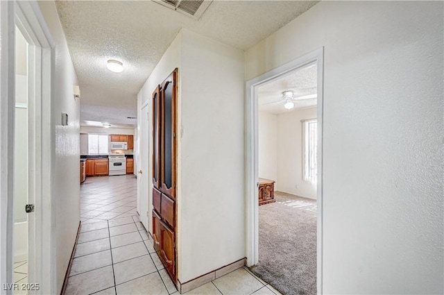 5121 Gains Mill St, Las Vegas, NV 89122 - hall featuring a textured ceiling, light tile patterned floors, and healthy amount of natural light