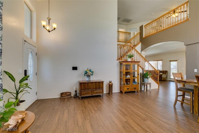 6109 Sandstone Mesa Dr, Las Vegas, NV 89130 - foyer entrance featuring a high ceiling, arched walkways, stairway, wood finished floors, and a chandelier