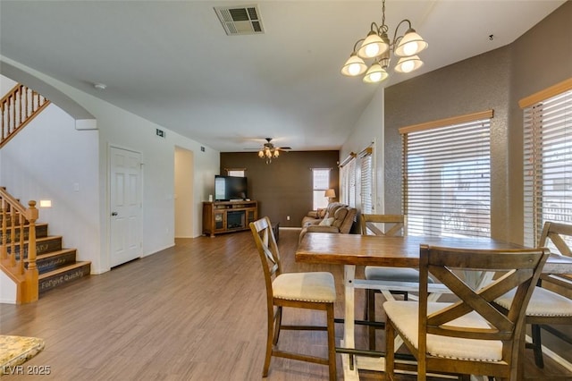 6109 Sandstone Mesa Dr, Las Vegas, NV 89130 - dining space featuring stairway, light wood-style flooring, arched walkways, a ceiling fan, and plenty of natural light