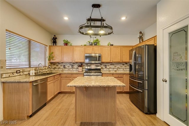 6109 Sandstone Mesa Dr, Las Vegas, NV 89130 - kitchen featuring appliances with stainless steel finishes, tasteful backsplash, light stone countertops, a kitchen island, and light brown cabinetry