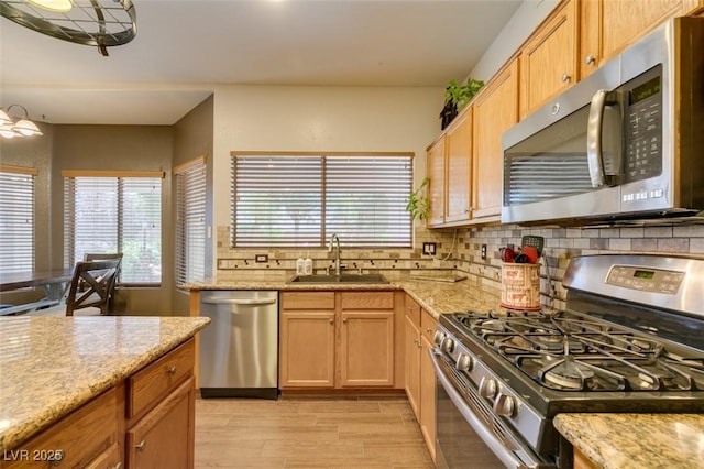 6109 Sandstone Mesa Dr, Las Vegas, NV 89130 - kitchen with stainless steel appliances, decorative backsplash, light stone counters, and light wood-type flooring