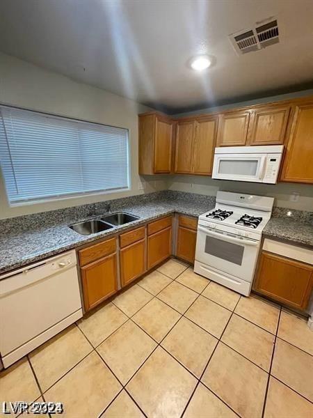 5413 Bristol Bend Ct, Las Vegas, NV 89135 - kitchen with white appliances, light tile patterned flooring, and dark countertops