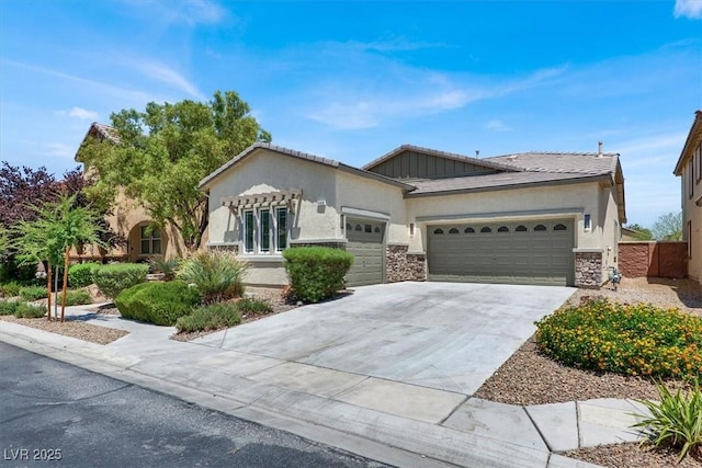 5908 Big Horn View St, North Las Vegas, NV 89031 - view of front of home featuring a garage, concrete driveway, stone siding, and stucco siding
