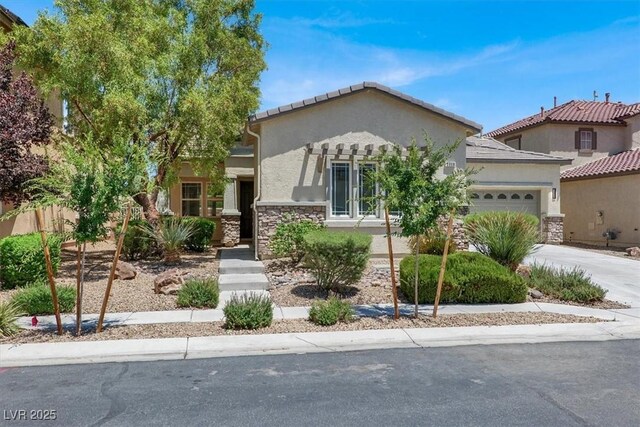 5908 Big Horn View St, North Las Vegas, NV 89031 - view of front of property with stucco siding, a garage, stone siding, driveway, and a tiled roof