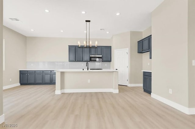5908 Big Horn View St, North Las Vegas, NV 89031 - kitchen with stainless steel microwave, light wood-style floors, tasteful backsplash, light countertops, and recessed lighting