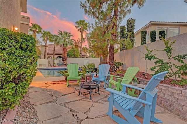4651 Munich Ct, Las Vegas, NV 89147 - patio terrace at dusk with a fire pit, a patio, and a fenced backyard