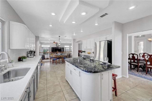 4651 Munich Ct, Las Vegas, NV 89147 - kitchen featuring freestanding refrigerator, a center island, recessed lighting, healthy amount of natural light, and light tile patterned floors