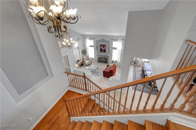 4651 Munich Ct, Las Vegas, NV 89147 - staircase featuring a chandelier, wood finished floors, and a fireplace