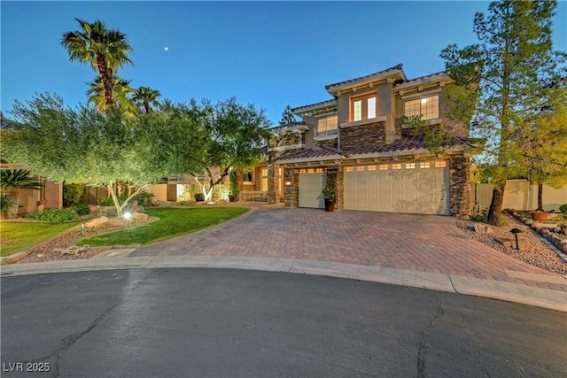 4651 Munich Ct, Las Vegas, NV 89147 - mediterranean / spanish home featuring decorative driveway, stone siding, an attached garage, a tile roof, and stucco siding