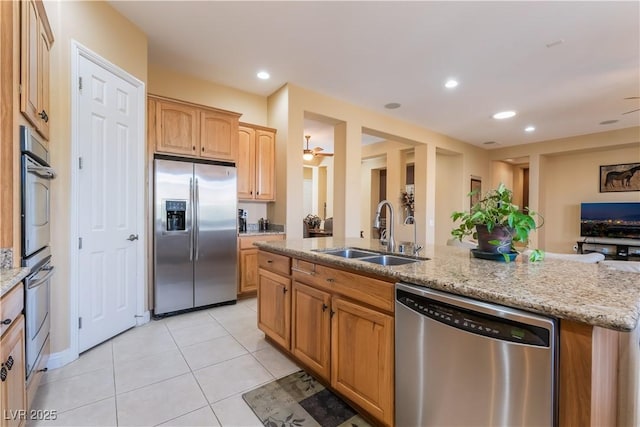 12276 Caminita Pl, Las Vegas, NV 89138 - kitchen featuring stainless steel appliances, open floor plan, light stone countertops, light tile patterned flooring, and a kitchen island with sink