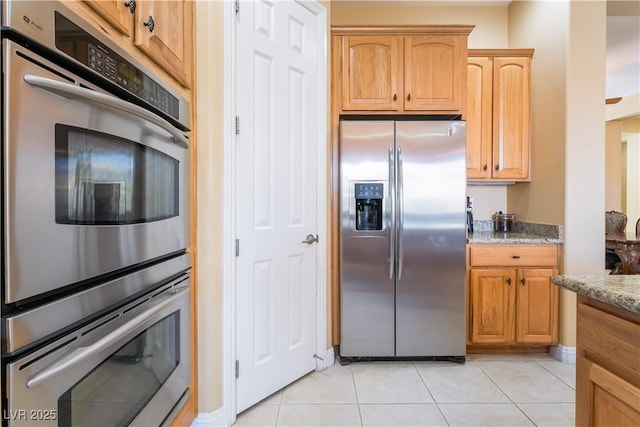 12276 Caminita Pl, Las Vegas, NV 89138 - kitchen featuring appliances with stainless steel finishes, light stone counters, and light tile patterned floors